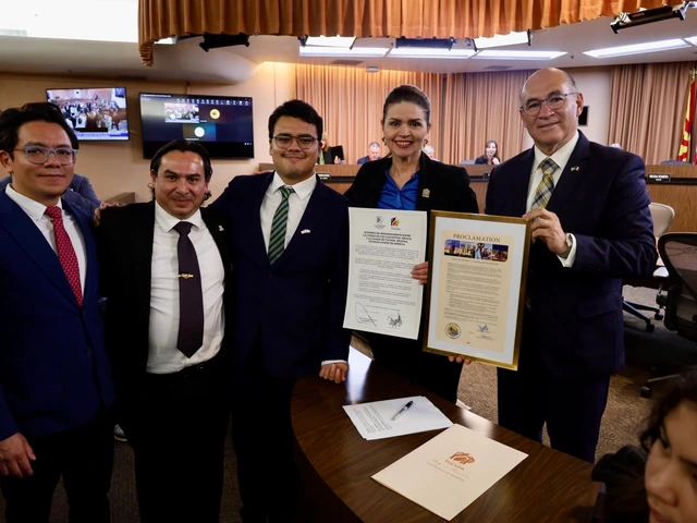 Four men and one woman in black suits stand together, holding ceremonial proclamations