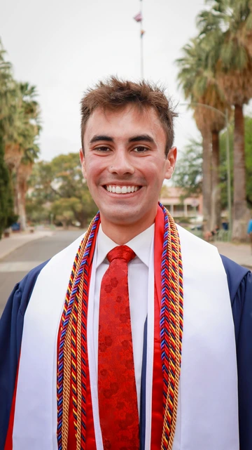 Student outside wearing graduation regalia